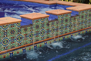 Spanish tile design mixed with solid-colored glazed porcelain tiles brings this pool to a new dimension. 