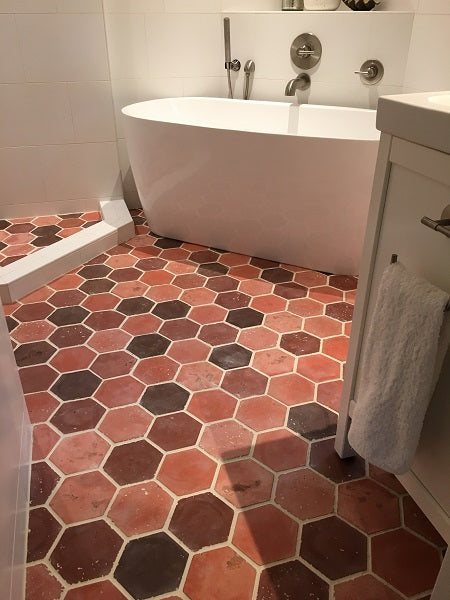 Hexagon cement tile in a warm, random colorway are used for this bathroom floor.
